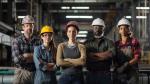A group of construction workers in helmets and work clothes posing for the camera