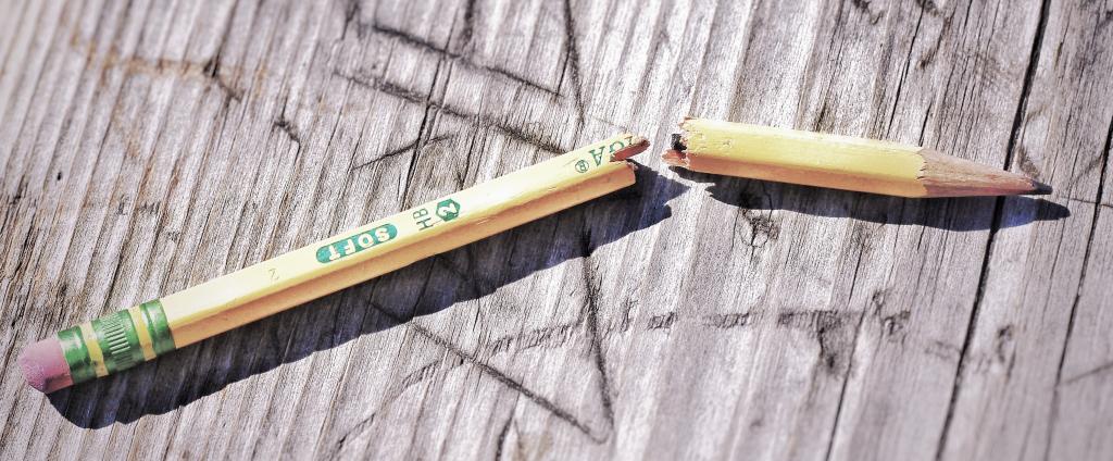 A BROKEN PENCIL ON A WOODEN TABLE