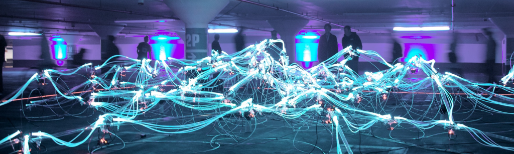 People looking at lights and wires connecting each other